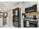 Modern kitchen equipped with black stainless-steel appliances and white cabinetry with tile backsplash at 12840 Sophia Cir, Largo, FL 33774