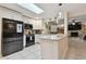 Kitchen with white cabinetry, black stainless-steel appliances, and breakfast bar open to living room at 12840 Sophia Cir, Largo, FL 33774