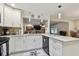 Kitchen with white cabinetry, stainless steel appliances, and open to the living room with fireplace at 12840 Sophia Cir, Largo, FL 33774