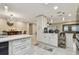 Bright, white kitchen with stainless-steel appliances and skylight open to dining room and living room at 12840 Sophia Cir, Largo, FL 33774