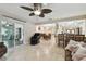 Open-concept living room featuring tile flooring, a unique ceiling fan, dining area, and an eat-in kitchen at 12840 Sophia Cir, Largo, FL 33774