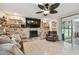 Cozy living room with a stone fireplace, floating shelves, and access to the outdoor pool area at 12840 Sophia Cir, Largo, FL 33774
