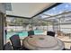Enjoy outdoor dining in this screened pool area with a large table and comfortable seating for entertaining at 12840 Sophia Cir, Largo, FL 33774