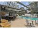 Inviting screened-in pool area with comfortable seating and dining space for outdoor enjoyment at 12840 Sophia Cir, Largo, FL 33774