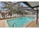Lovely screened-in pool with ample sunlight, surrounded by lush landscaping and privacy fencing at 12840 Sophia Cir, Largo, FL 33774