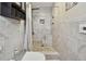 Bright bathroom shower with a tiled surround, stone floor, and a built-in bench for comfortable showering at 12840 Sophia Cir, Largo, FL 33774