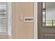 Close up of wall-mounted smart home controls and a security system sign are featured, ensuring modern convenience and security at 12840 Sophia Cir, Largo, FL 33774