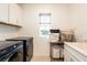 Bright laundry room with washer, dryer, and cabinets at 12902 Brookside Moss Dr, Riverview, FL 33579