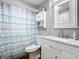 Simple bathroom with white vanity, grey tile, and patterned shower curtain at 141 Singapore Rd, Punta Gorda, FL 33950