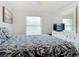 Cozy bedroom with a TV, dresser, and patterned bedding at 141 Singapore Rd, Punta Gorda, FL 33950