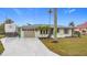 Newly renovated home with a large driveway and tropical landscaping at 141 Singapore Rd, Punta Gorda, FL 33950