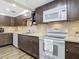 Well-equipped kitchen with white appliances and dark wood cabinets at 141 Singapore Rd, Punta Gorda, FL 33950