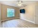 Bedroom with ceiling fan, window, laminate floor, and mounted TV at 18817 Chaville Rd, Lutz, FL 33558