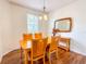 Bright dining room with a wood table and chairs, decorative mirror, and hardwood floors at 2071 Sifield Greens Way # 103, Sun City Center, FL 33573