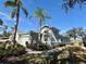 Single-story villa with attached garage, palm trees, and manicured landscaping at 2071 Sifield Greens Way # 103, Sun City Center, FL 33573