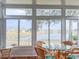 Sunroom with lake view and glass table surrounded by wicker chairs at 2071 Sifield Greens Way # 103, Sun City Center, FL 33573