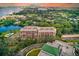 Stunning aerial view of the condo building, pool, and surrounding landscape with water views at 220 Belleview Blvd # 811, Belleair, FL 33756