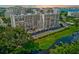 Aerial view of the building, balconies, swimming pool, and serene waterway, offering a blend of relaxation and luxury at 220 Belleview Blvd # 811, Belleair, FL 33756