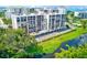 Aerial view of the building, balconies, swimming pool, and serene waterway, offering a blend of relaxation and luxury at 220 Belleview Blvd # 811, Belleair, FL 33756