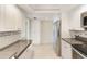 Kitchen featuring stainless steel appliances, granite counters, and white cabinetry at 220 Belleview Blvd # 811, Belleair, FL 33756