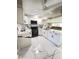 Modern kitchen with white cabinets, marble countertops, and black appliances at 2910 W Burke St, Tampa, FL 33614