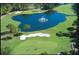 Scenic aerial view of golf course pond with fountain and surrounding lush green fairways and sand traps at 36750 Us Highway 19 # 24209, Palm Harbor, FL 34684