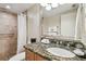 Bathroom featuring granite countertops, a shower with tile surround, and a large mirror at 36750 Us Highway 19 # 24209, Palm Harbor, FL 34684