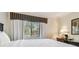 Bright bedroom with a window view, side table and black desk at 36750 Us Highway 19 # 24209, Palm Harbor, FL 34684