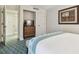 Cozy bedroom with a wooden dresser, closet, and blue patterned carpeting at 36750 Us Highway 19 # 24209, Palm Harbor, FL 34684
