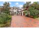 Luxury two-story home with brick driveway, lush landscaping, and three-car garage at 4902 Carranza Ct, Tampa, FL 33616
