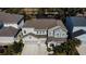 Two-story house with gray siding, three-car garage, and landscaped yard at 5709 Camila Song Ln, Tampa, FL 33625