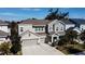 Two-story house with gray siding, three-car garage, and landscaped yard at 5709 Camila Song Ln, Tampa, FL 33625