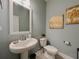 Modern bathroom with pedestal sink, toilet and stylish wall art at 5709 Camila Song Ln, Tampa, FL 33625