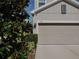 Three-car garage with neutral-colored doors at 5709 Camila Song Ln, Tampa, FL 33625
