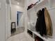 White hallway with built-in storage bench and coat hooks at 5709 Camila Song Ln, Tampa, FL 33625