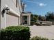 Landscaped side yard with a three-car garage at 5709 Camila Song Ln, Tampa, FL 33625