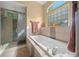 Relaxing bathroom with soaking tub, walk-in shower, and large window at 628 Erin Way, Brooksville, FL 34601