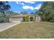 Green house with red door, two car garage, and landscaped yard at 628 Erin Way, Brooksville, FL 34601