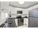 Modern kitchen with white cabinets, granite counters, and stainless steel appliances at 7095 17Th N Way, St Petersburg, FL 33702