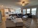 Open living space with sectional sofa, large windows, and kitchen island at 8365 Capstone Ranch Dr, New Port Richey, FL 34655
