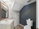 Clean bathroom with toilet, sink, and dark accent wall at 9626 Charlesberg Dr, Tampa, FL 33635