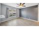 Bright bedroom with wood-look floors, ceiling fan, and large window at 9626 Charlesberg Dr, Tampa, FL 33635