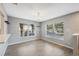 Bright dining area with gray walls, wood-look tile floors, and a chandelier at 9626 Charlesberg Dr, Tampa, FL 33635