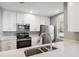 Modern kitchen with white cabinets, stainless steel appliances, and quartz countertops at 9626 Charlesberg Dr, Tampa, FL 33635