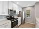 Updated kitchen with white cabinets, stainless steel appliances, and quartz countertops at 9626 Charlesberg Dr, Tampa, FL 33635