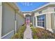 Front entry with walkway, landscaping, and a pink door at 1031 Emerald Dunes Dr, Sun City Center, FL 33573
