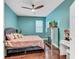 Relaxing bedroom with teal walls, hardwood floors, and a ceiling fan at 10409 Waterstone Dr, Riverview, FL 33578