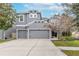 Two-story house with gray siding, two-car garage, and landscaping at 10409 Waterstone Dr, Riverview, FL 33578