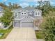 Two-story house with gray siding, two-car garage, and driveway at 10409 Waterstone Dr, Riverview, FL 33578