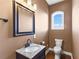 Small powder room with granite vanity and arched window at 110 Driftwood Ln, Largo, FL 33770